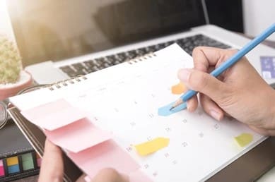 Calendar with many sticky notes keeps track of payment schedule.