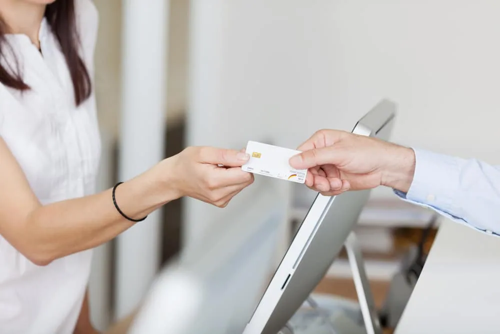 An eye care provider accepting a client's payment